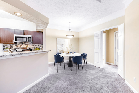 a dining area with a table and chairs and a kitchen in the background at Elan at Mallard Creek Apartment Homes, Charlotte, NC